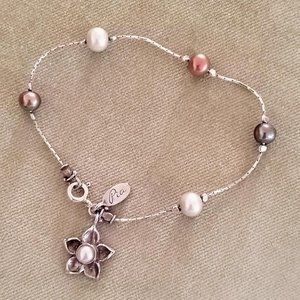 Flower shaped charm with a a white pearl